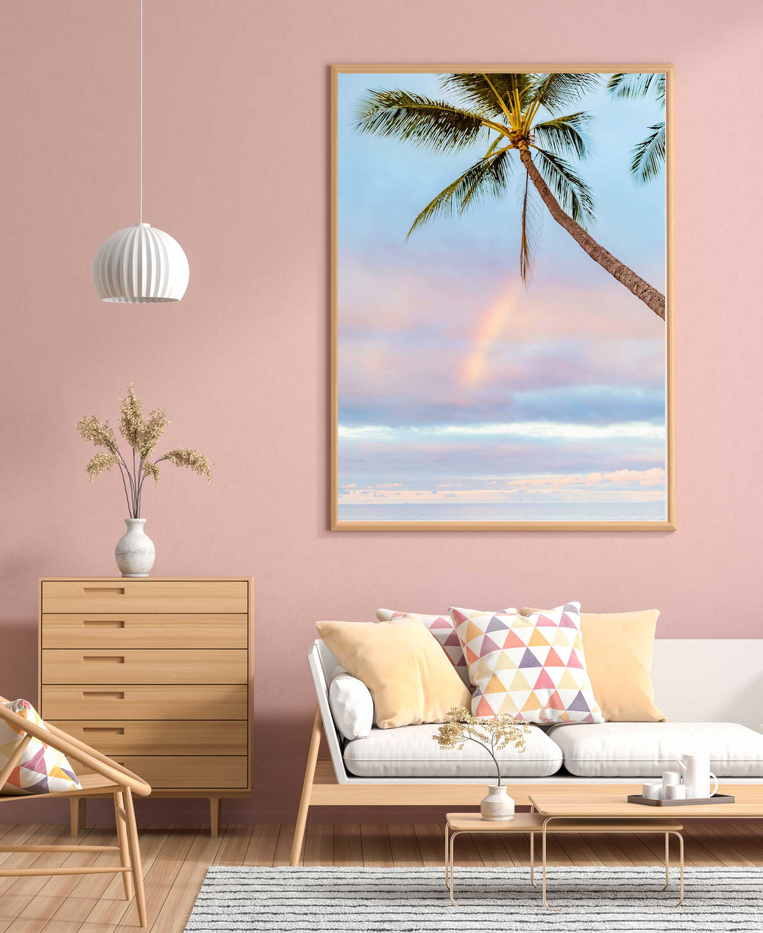 a rainbow on the ocean is framed by a draping palm tree in maui hawaii